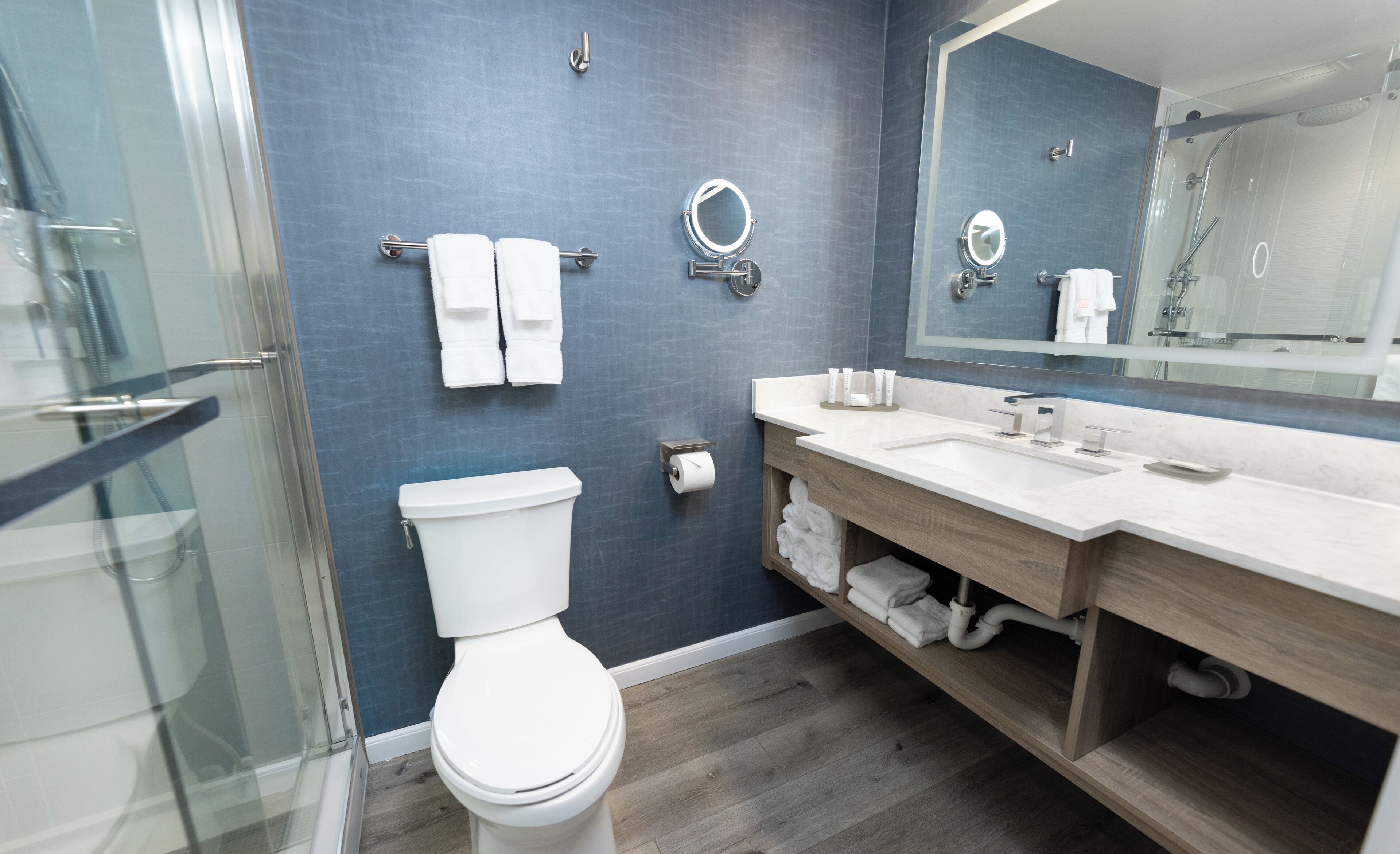A modern bathroom with a toilet, sink, and shower.