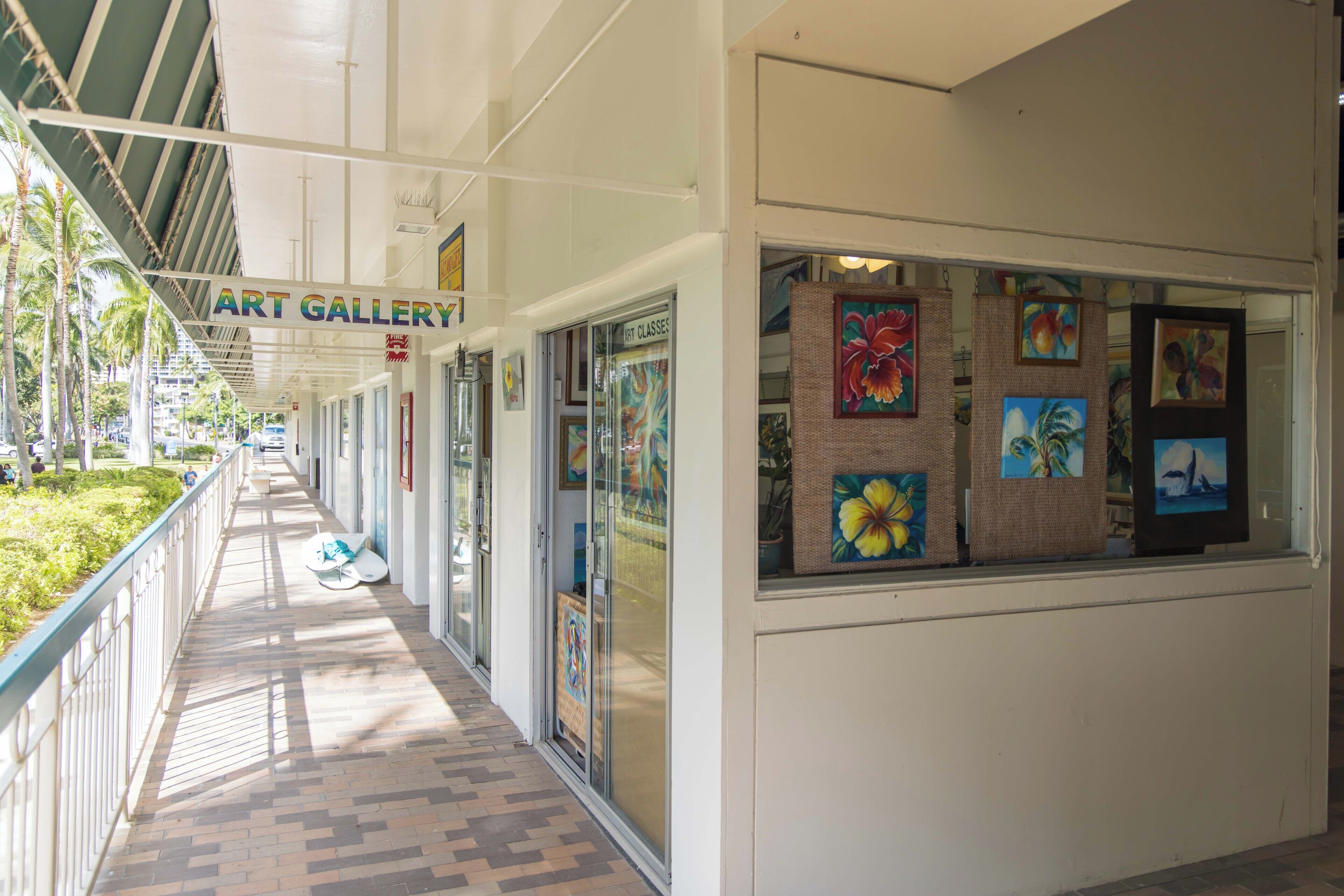 Une galerie d’art dotée d’une allée couverte et de portes en verre.