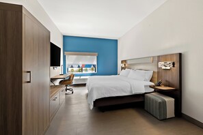 Un dormitorio moderno con cama, mesita de noche y escritorio con silla.