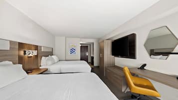 A modern hotel room with two beds, a desk, a chair, a TV, and a mirror.
