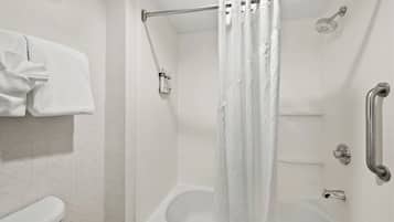 Et badeværelse med brusebad, toilet og håndklædetørrestativ.