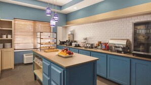 A modern kitchen with a central island, blue cabinetry, and a brick backsplash. - Country Inn & Suites by Radisson, Beaufort West, SC (Beaufort)