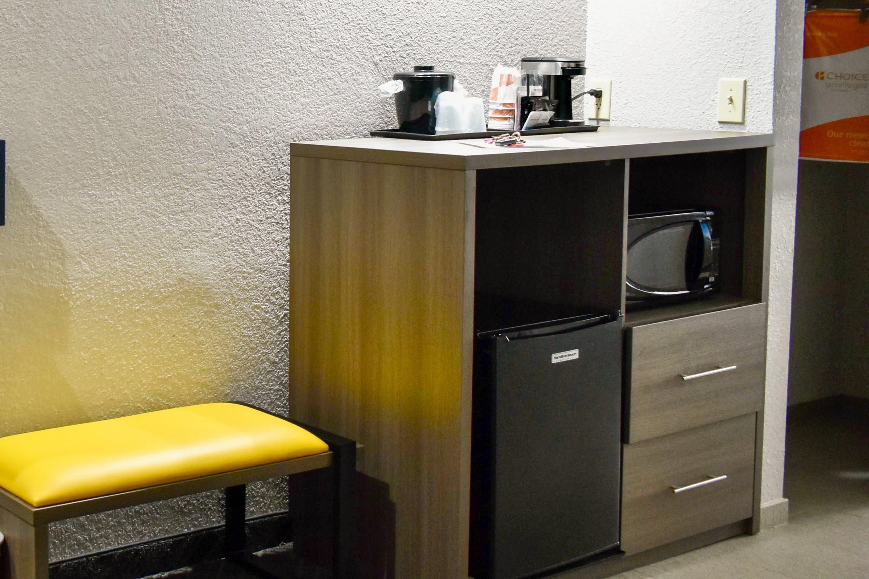 A compact kitchenette with a microwave, a coffee maker, and a small refrigerator.