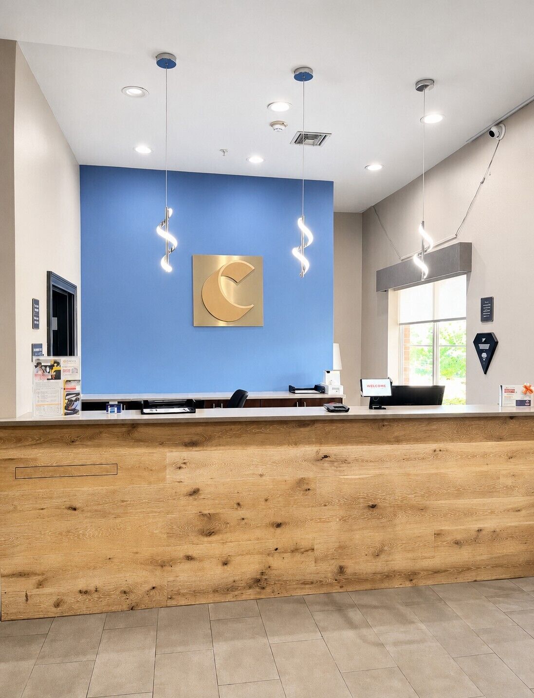 A reception desk with a blue wall, a gold crescent moon design, and a wooden counter.