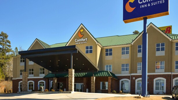 A Comfort Inn & Suites hotel with a covered entrance, multiple windows, and a green roof.
