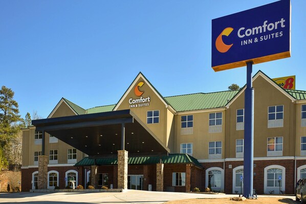 A Comfort Inn & Suites hotel with a covered entrance, multiple windows, and a green roof.