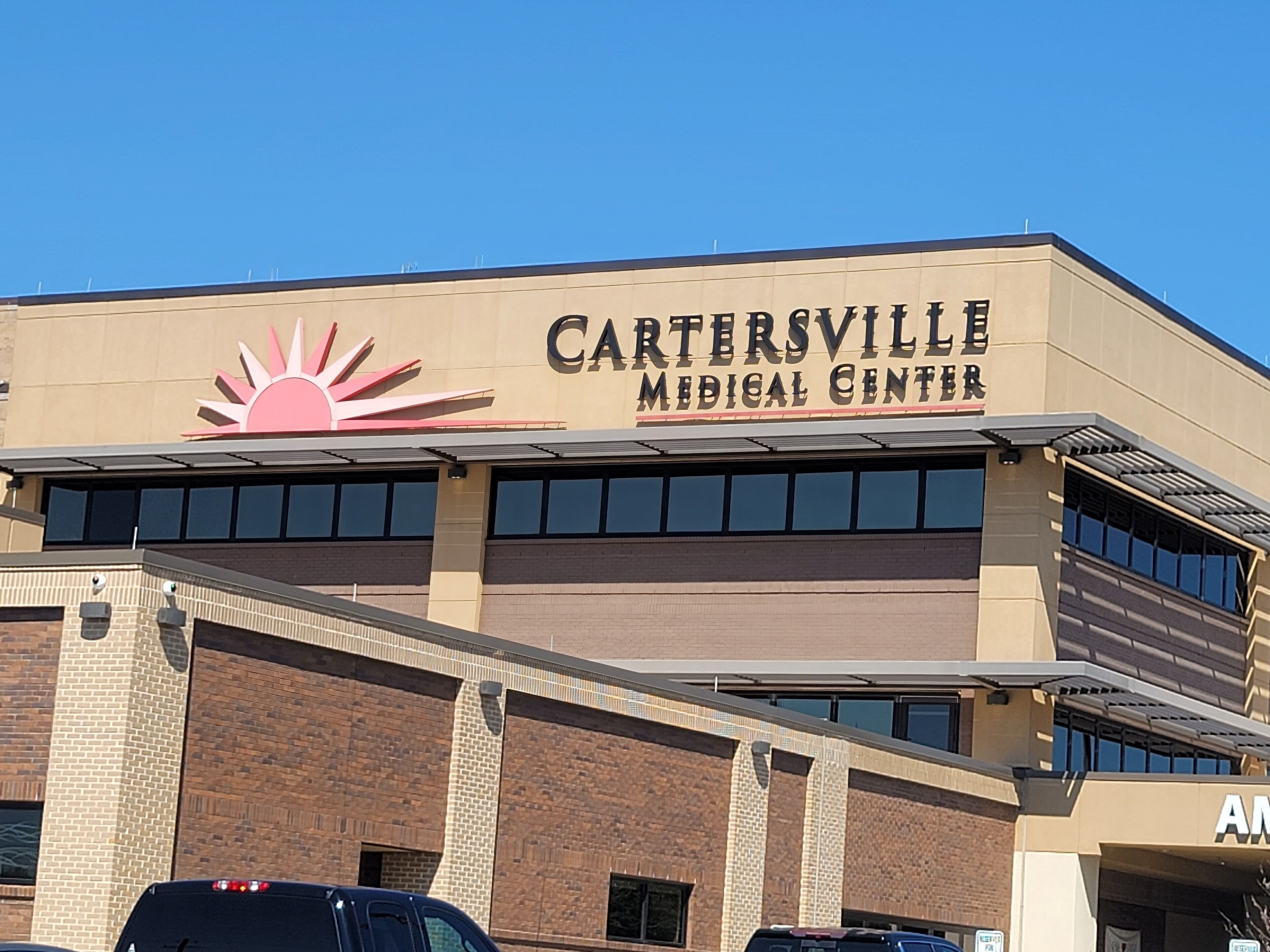 A building with a sign reading "CARTERSVILLE MEDICAL CENTER" and a sun logo.