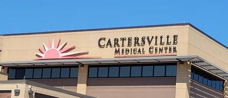 A building with a sign reading "CARTERSVILLE MEDICAL CENTER" and a sun logo.