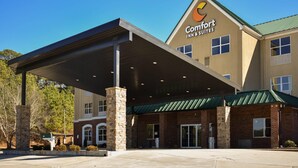Een Comfort Inn & Suites gebouw met een overdekte ingang, een gevel van baksteen en een groen dak.