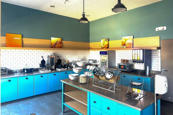 A kitchen with blue cabinets, a coffee machine, and a microwave. - Comfort Inn & Suites Cartersville - Emerson Lake Point (Cartersville)