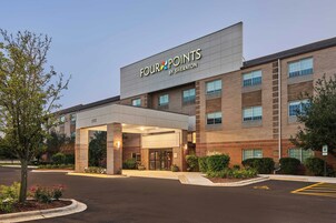Un hotel Four Points by Sheraton con fachada de ladrillo, amplias ventanas y un acceso cubierto.