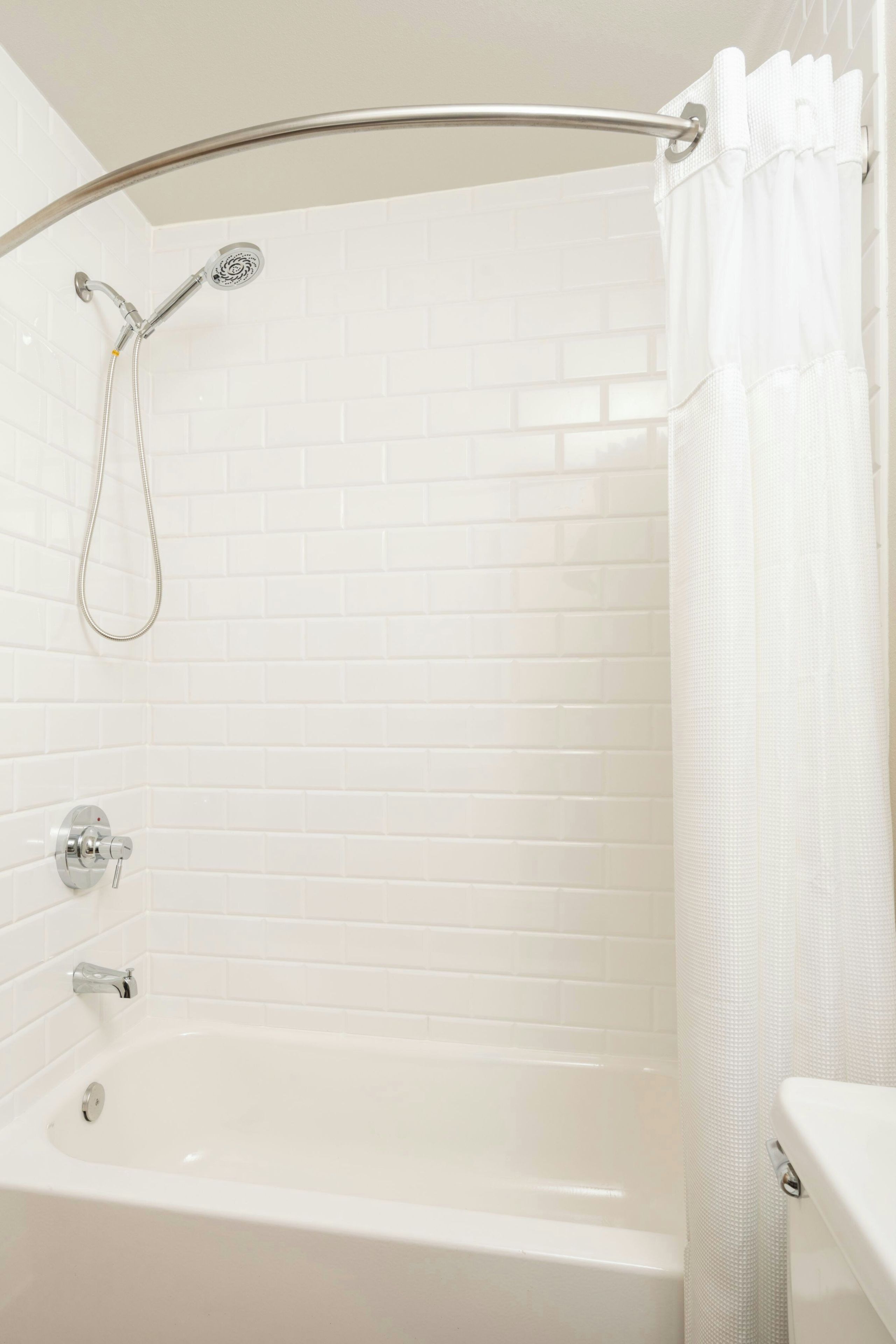 Une salle de bain avec une baignoire, une douche et un rideau de douche.