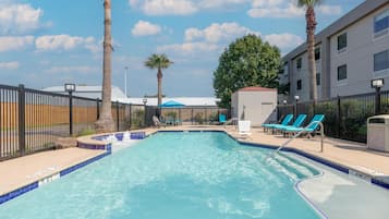 Alberca al aire libre y camastros