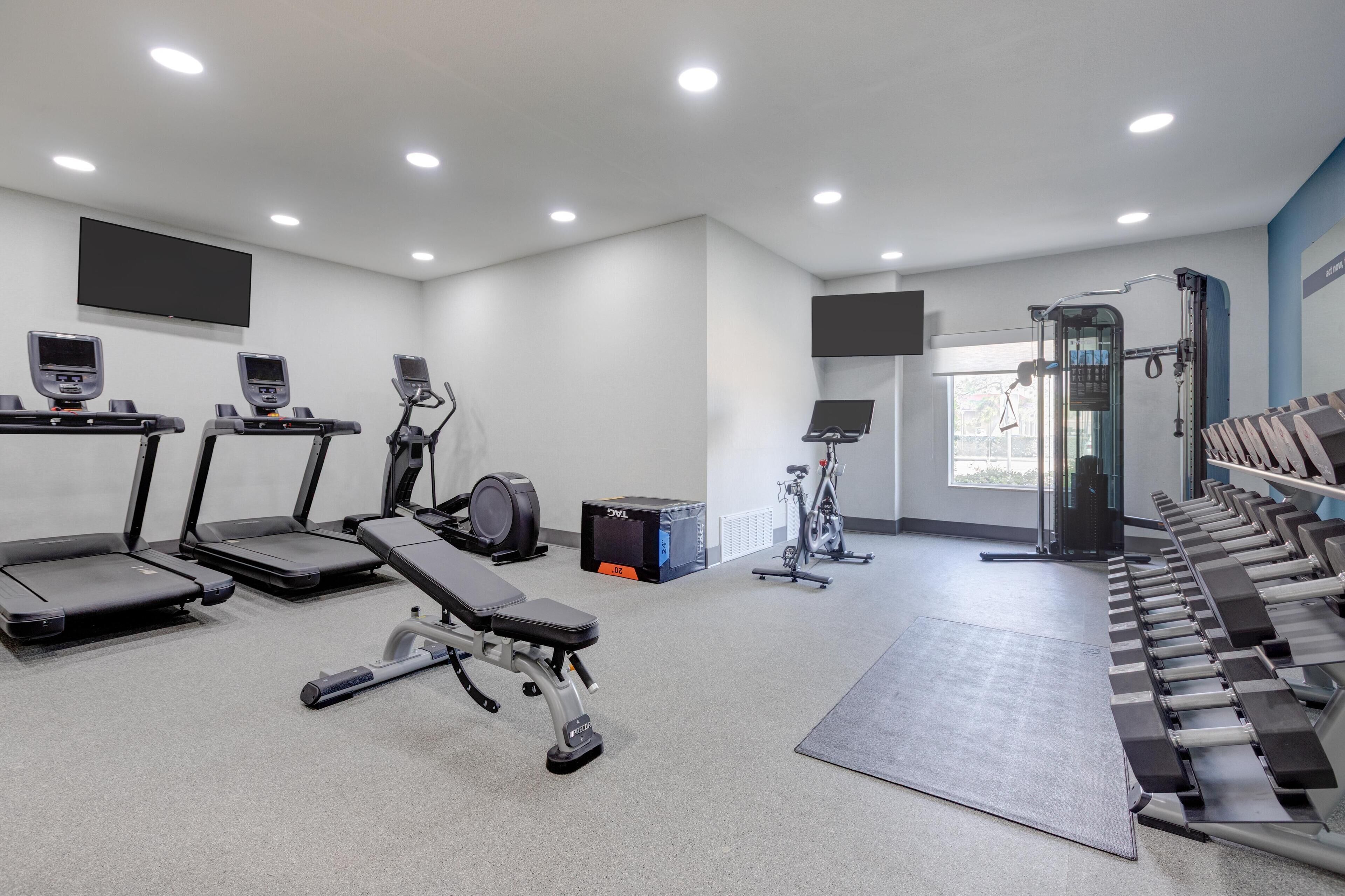 A gym with treadmills, stationary bikes, and weight machines.