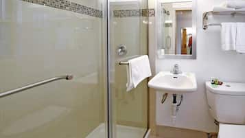 A modern bathroom with a glass-enclosed shower, a white sink, and a toilet.