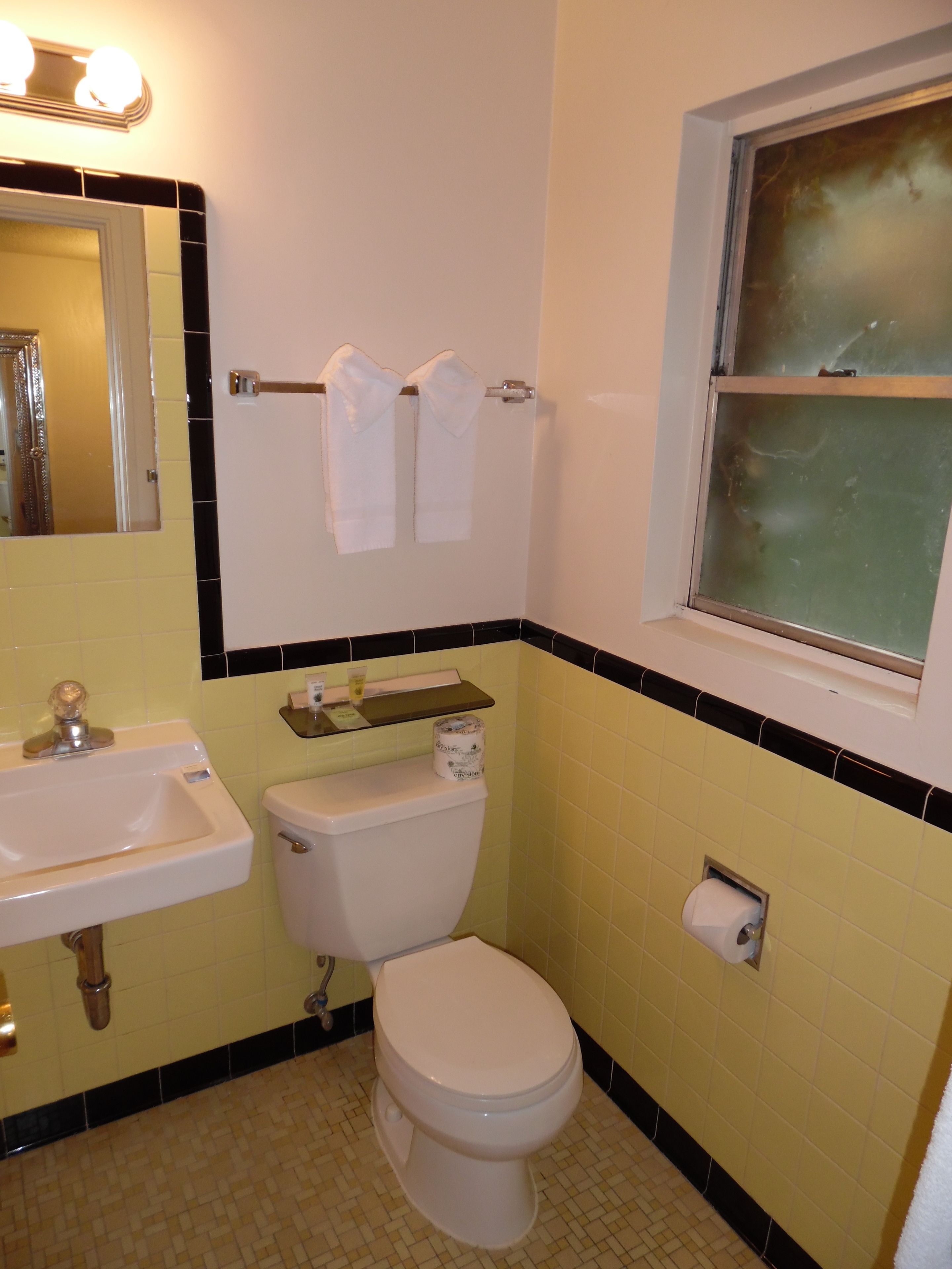 Un baño con lavabo, inodoro y espejo con iluminación.