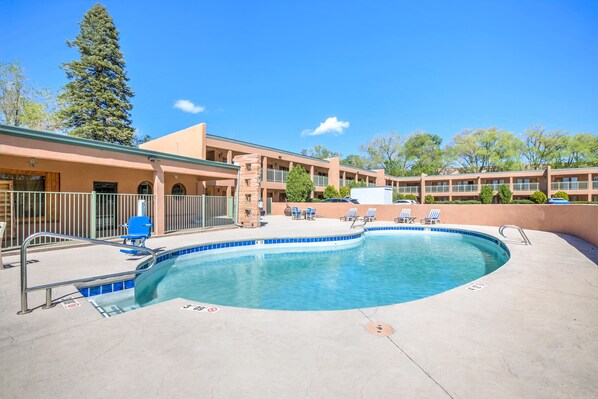 Relax by the pool surrounded by lush surroundings and comfortable lounge chairs.