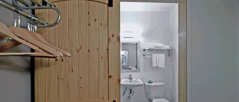 A wooden door with a towel rack and a sliding barn door mechanism.