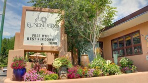 The El Sendero Inn sign with a free wifi claim and a flower garden in front. - El Sendero Inn, an Ascend Collection Hotel (Santa Fe)
