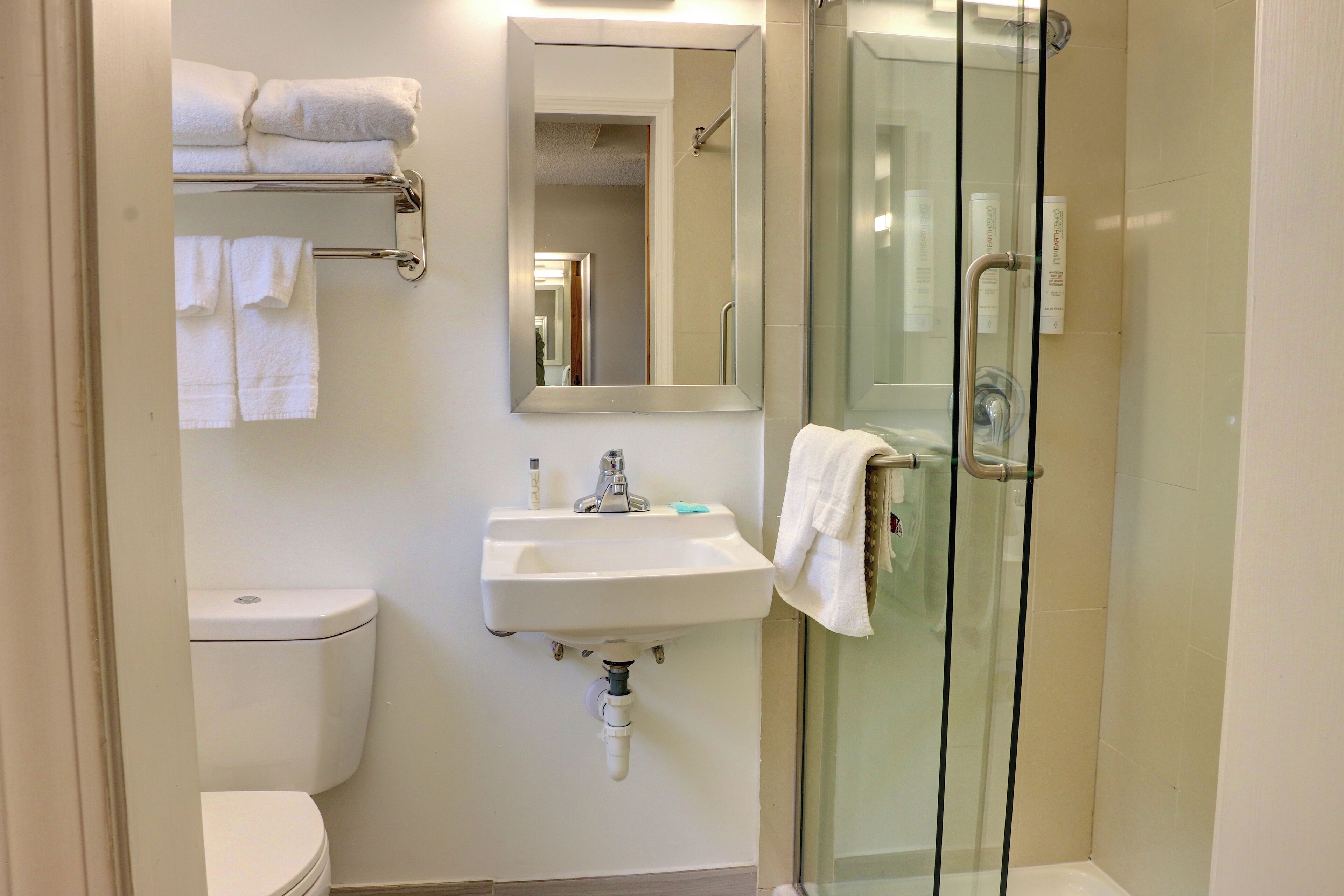 A bathroom with a toilet, sink, and glass-enclosed shower.