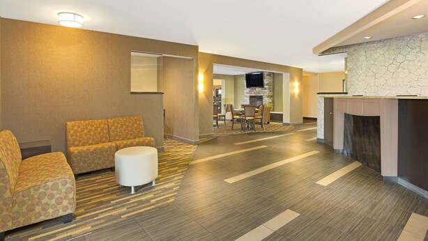 Un vestíbulo de hotel con sofá, reposapiés y chimenea.