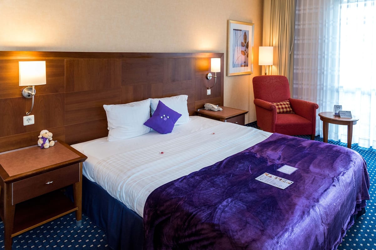 Luxe beddengoed, een kluis op de kamer, een bureau, een laptopwerkplek