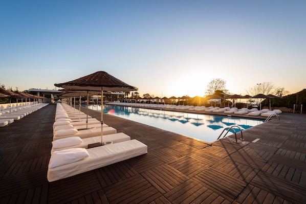 Una piscina cubierta, una piscina al aire libre de temporada, sombrillas