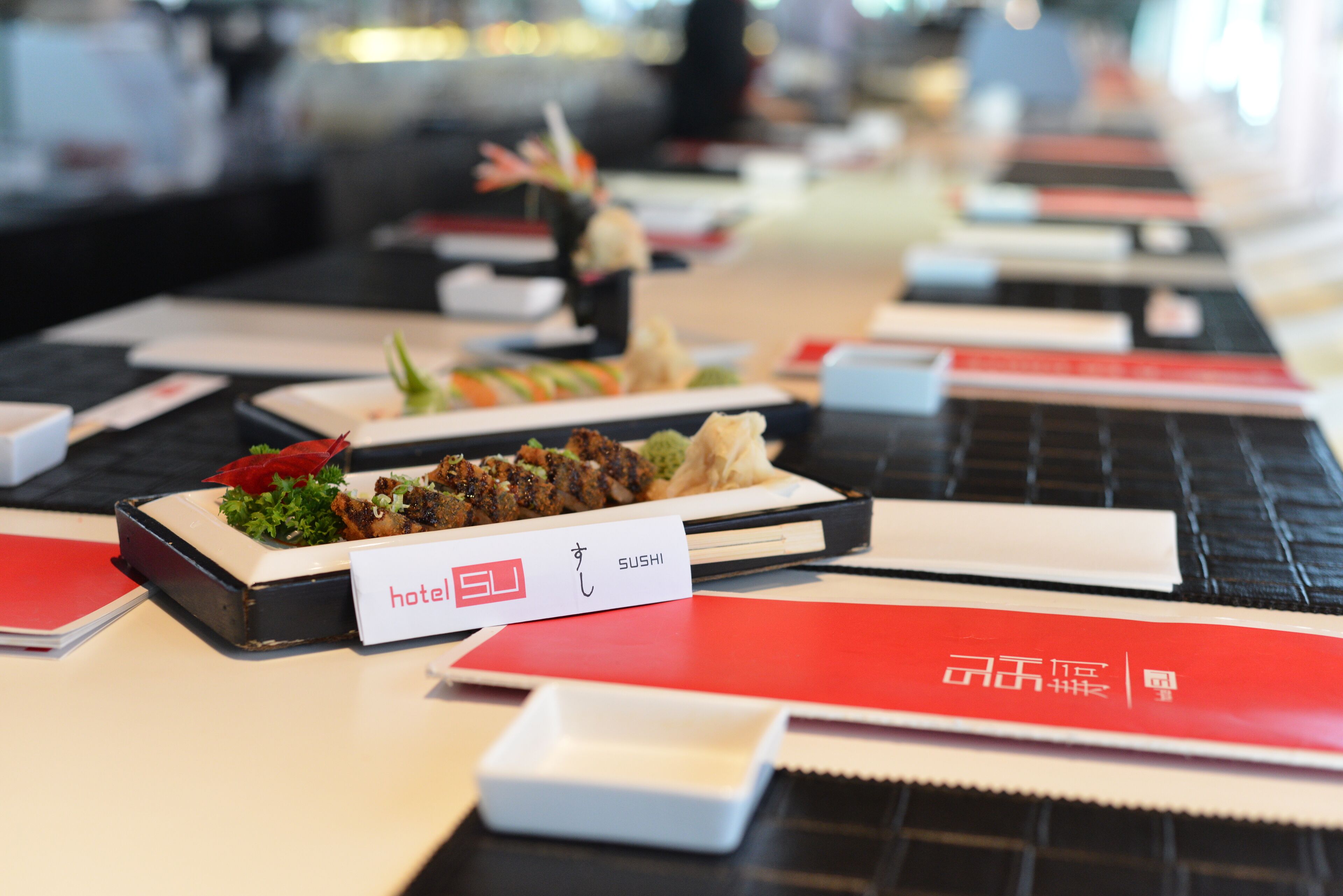 Sushi-baari, jossa on tarjolla monenlaisia annoksia, ja kyltti, josta ilmenee, että kyseessä on sushiravintola.
