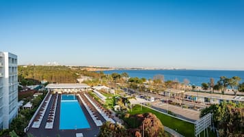 Een hotel met een zwembad, terras en uitzicht op zee.
