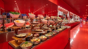 A buffet with various food items and bowls, set in a room with a red ceiling and walls. - Hotel SU & Aqualand (Antalya)