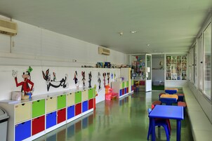 Un aula con taquillas de colores, decoraciones de personajes de caricatura y un largo banco a lo largo de la pared.
