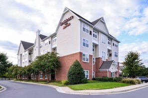 Un hôtel à plusieurs étages, doté d’une façade en briques et de bordures blanches, et arborant une enseigne bien visible pour le « Residence Inn Marriott ».