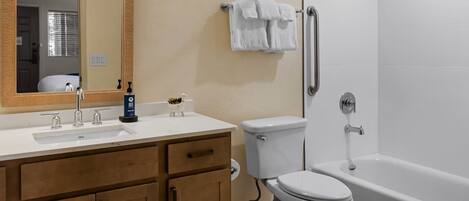 Une salle de bain avec un lavabo, des toilettes et une baignoire.
