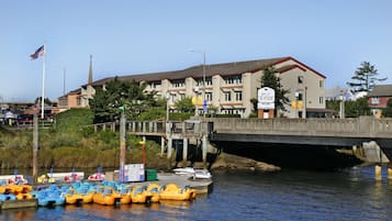 A waterfront hotel with a bridge, boats, and a sign welcoming guests.