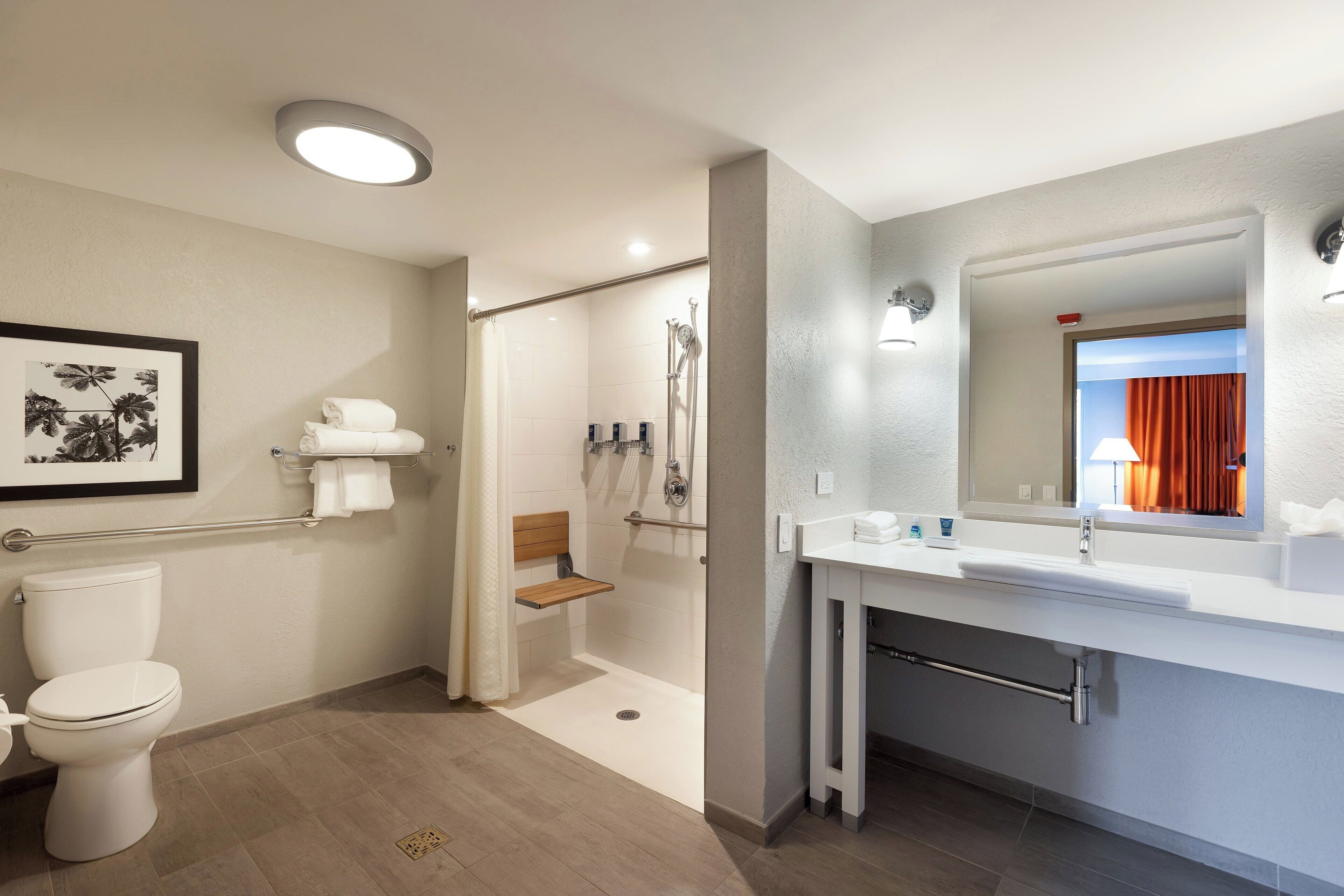 A modern bathroom with a toilet, shower, and sink.