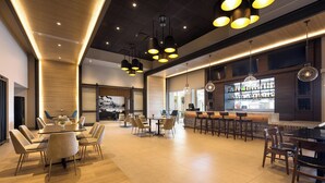 A modern restaurant with a bar area, wooden flooring, and contemporary lighting fixtures. - Four Points by Sheraton Caguas Real Hotel & Casino (Caguas)