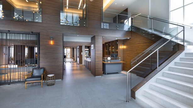 A spacious lobby with a staircase, wooden paneling, and a reception desk. - Four Points by Sheraton Caguas Real Hotel & Casino (Caguas)