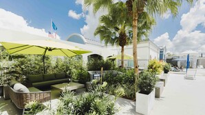 An outdoor patio area with seating, umbrellas, and potted plants. - Four Points by Sheraton Caguas Real Hotel & Casino (Caguas)