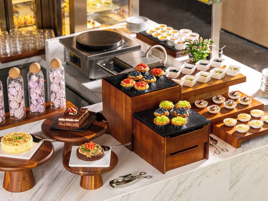 A buffet with various desserts and food items.