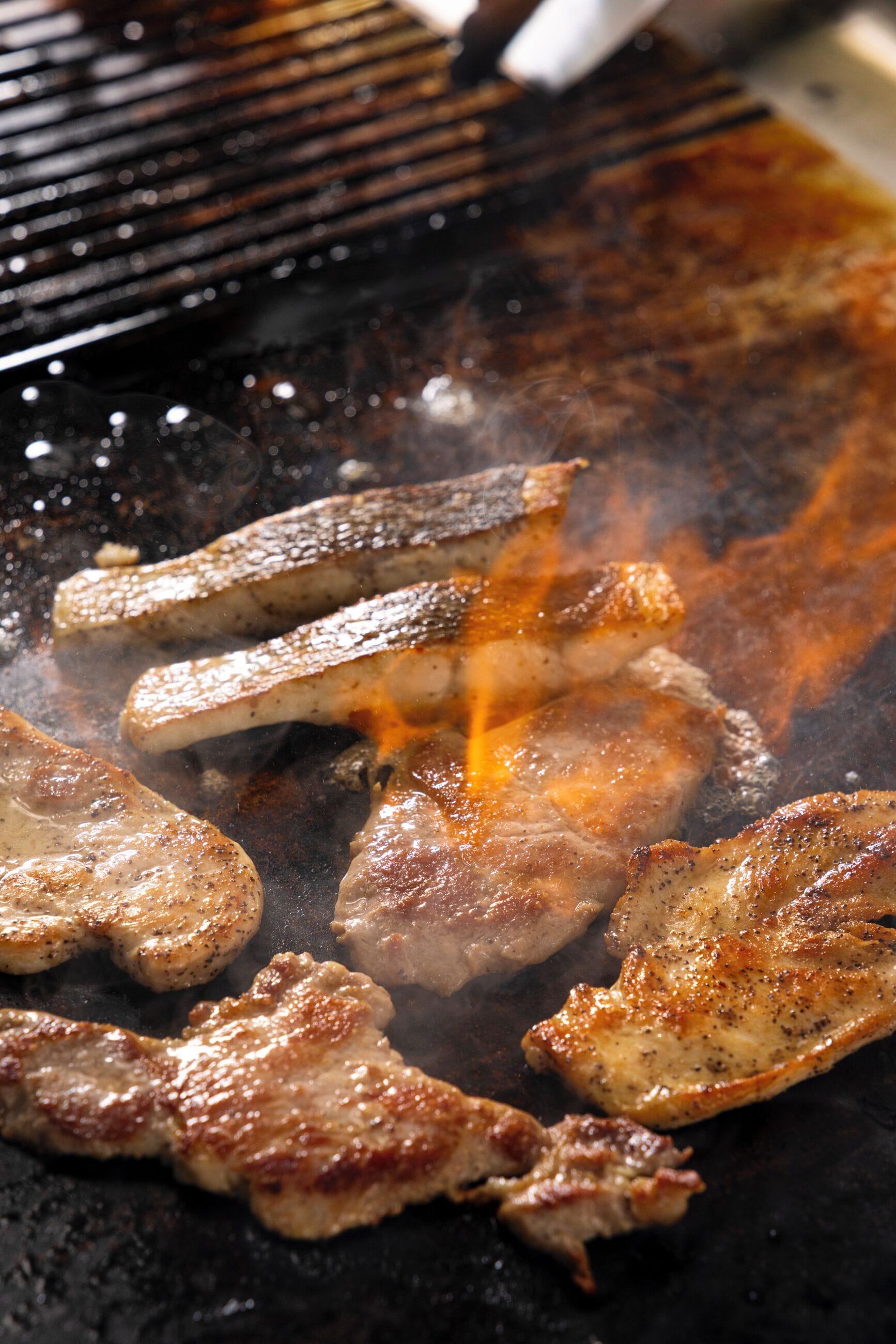 A close-up of meat being grilled on a barbecue.