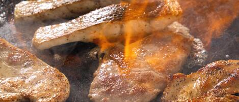 A close-up of meat being grilled on a barbecue.