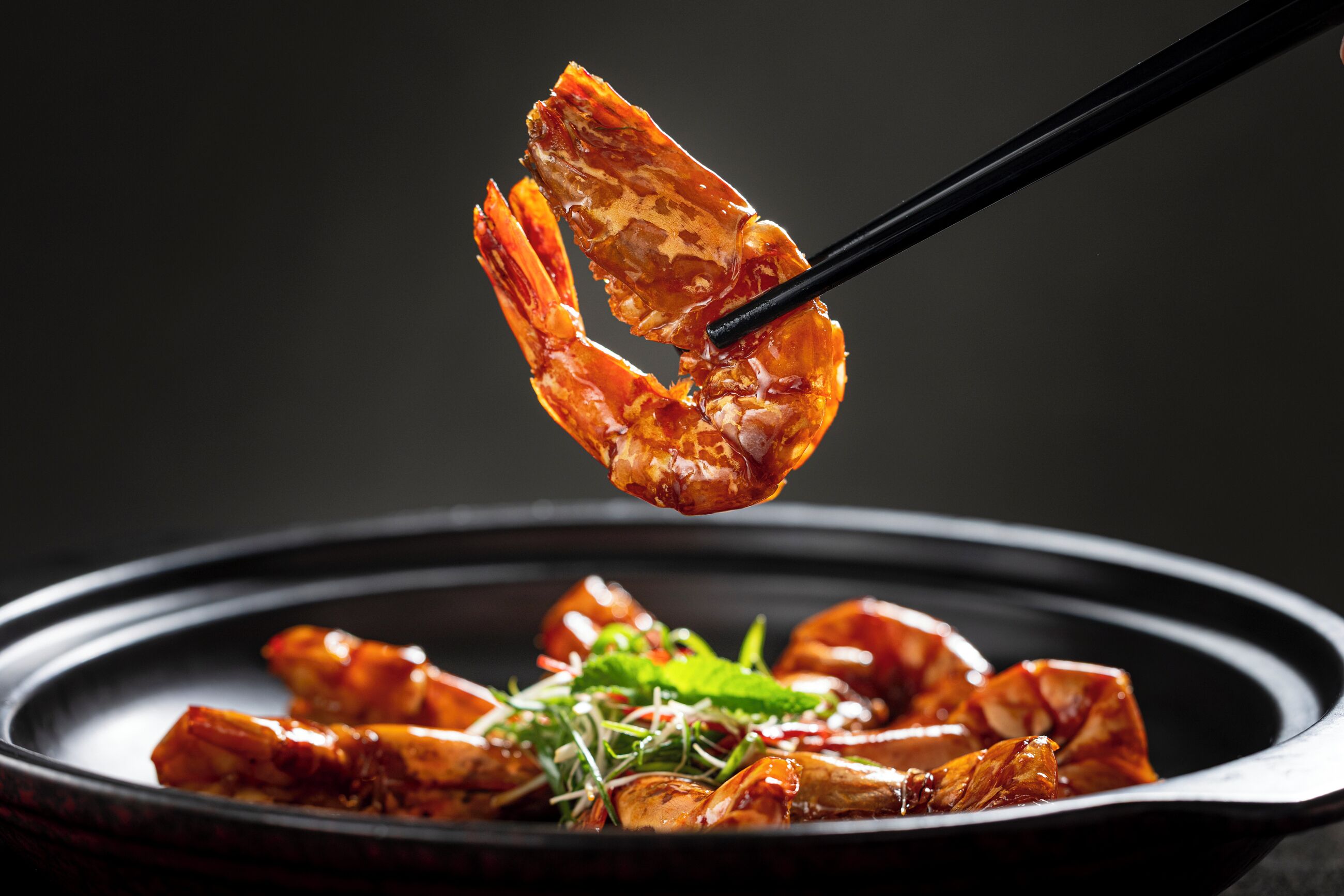 A dish with cooked shrimp and greens on a plate.