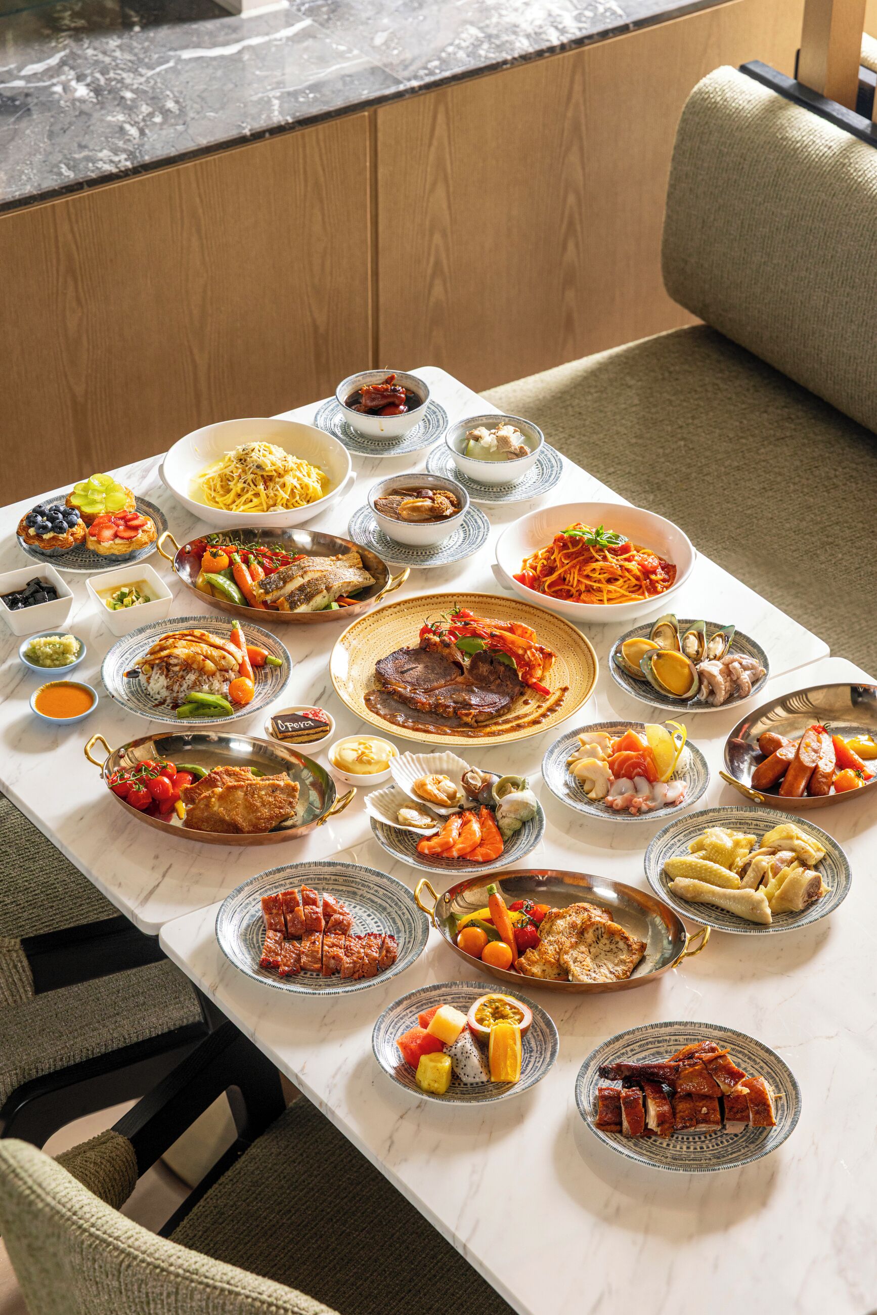 A dining table with various dishes, a sofa, and a view of a wooden floor and a window.
