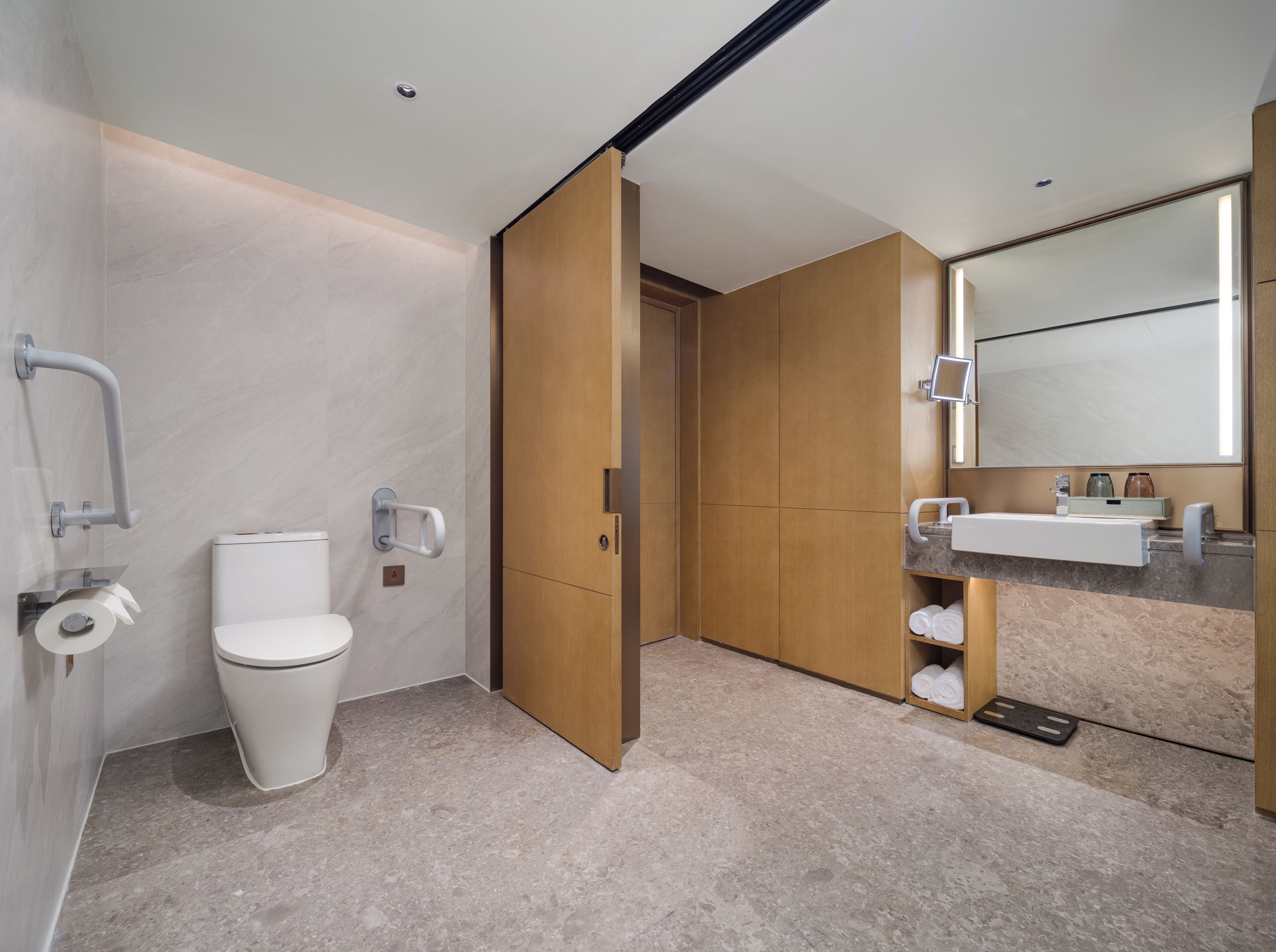 Een moderne badkamer met toilet, wastafel, spiegel en douchehoek.