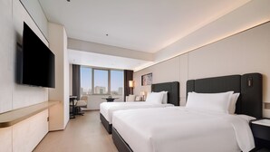 A hotel room with two beds, a TV, a desk, and a view of the city. - Canton Hotel Guangzhou, Tapestry Collection by Hilton (Guangzhou)