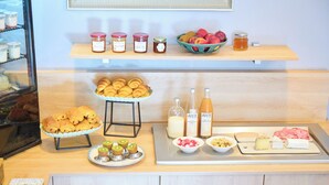A buffet with pastries, fruits, and condiments. - Hotel Aria (Nice)