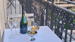 A balcony table with a bottle of champagne, two glasses, a bowl of olives, and a white tablecloth. - Hotel Aria (Nice)