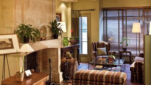 A cozy living room with a fireplace, comfortable seating, and various plants. - Hôtel Henri IV Rive Gauche (Paris)