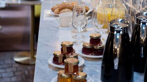 A breakfast table with pastries, fruit, and condiments. - Hôtel Henri IV Rive Gauche (Paris)