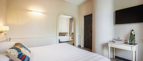 Une chambre d’hôtel avec un grand lit, un bureau, une télévision et un miroir.